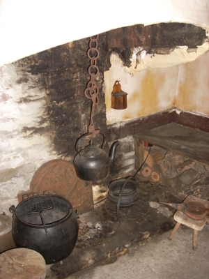 iron cooking equipment, wooden shelf-seat over kindling store